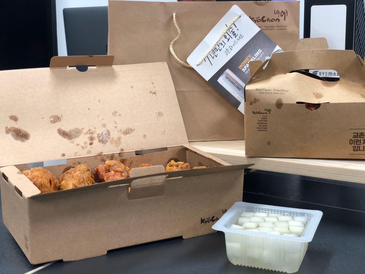 Boxed Kyochon Honey Chicken with a serving of pickled radish on the side.